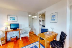 a living room with a table and chairs and a television at Maine Memories in Wiscasset