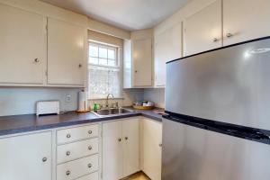 a kitchen with white cabinets and a stainless steel refrigerator at Maine Memories in Wiscasset