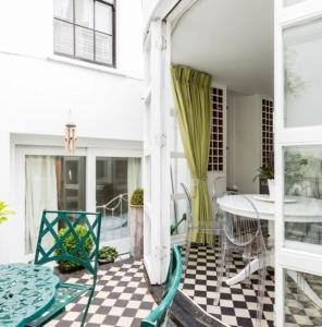 un porche con mesa y sillas en un suelo a cuadros en Marylebone Luxury 3BR Flat Elegant Central Gem, en Londres