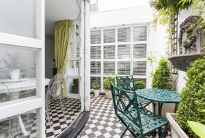 une terrasse couverte avec une table et des chaises. dans l'établissement Marylebone Luxury Duplex, à Londres