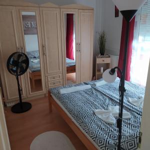 a bedroom with a bed with a lamp and a fan at Krénusz Vendégház. in Kaposvár