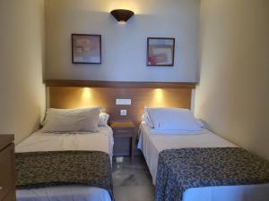 pokój hotelowy z dwoma łóżkami w pokoju w obiekcie Atardecer Beach Costa w mieście Benalmádena +19 zdjęć