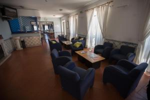 una sala d'attesa con sedie blu e un tavolo di HI Oeiras – Pousada de Juventude a Oeiras