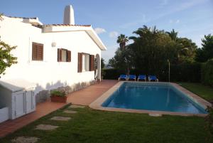 une maison avec une piscine à côté d'un bâtiment dans l'établissement Villa Lombardi, à Alaior