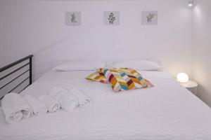 uma cama branca com toalhas e almofadas em La Palma Loft Located in the Heart of Catania em Catânia