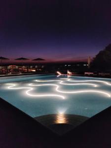 a swimming pool lit up at night at LaLiBay Resort & Spa - Adults Only in Perdika