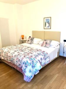a bedroom with a large bed with a floral bedspread at Cà Del Polsèt in Brenzone sul Garda