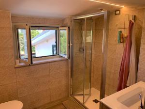uma casa de banho com um chuveiro, um lavatório e uma janela em COCCO HOUSE em Rocca San Giovanni