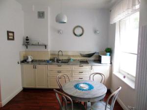 - une cuisine avec une table, des chaises et un évier dans l'établissement Kawalerka Muszelka, à Świnoujście