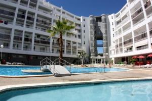 a swimming pool in front of a large building at For a Stay Royal Center in Salou