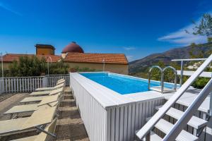 a swimming pool with chairs and a house at Villa Celentano in Vico Equense
