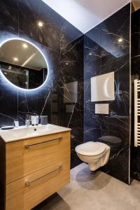 een badkamer met een toilet, een wastafel en een spiegel bij CMG Champs Elysées- Boetie 4GG in Parijs