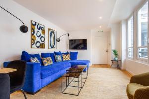 a blue couch in a living room with a window at CMG Champs Elysées- Boetie 4GG in Paris