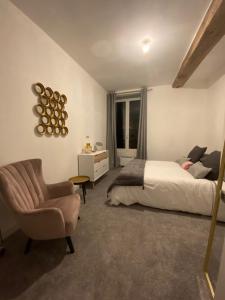 um quarto com uma cama e uma cadeira em Les remparts em Semur-en-Auxois