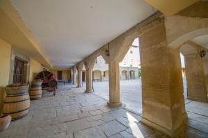 an empty hallway with columns and barrels in a building at Hospedería Bei.tu in Beire