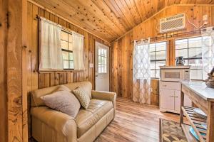 a living room with a couch in a wooden room at Couples Cabin with Luxury Deck, 1 Mi to Canyon Lake! in Canyon Lake