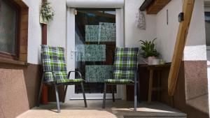 two chairs sitting on a porch in front of a door at Ferienwohnung Karoline Eisenach in Eisenach