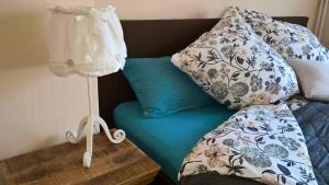 ein Bett mit blauer Bettwäsche und Kissen darauf in der Unterkunft Ferienwohnung Karoline Eisenach in Eisenach