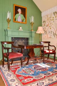 un soggiorno con tavolo, sedie e camino di The Munches Room at Buittle Castle a Castle Douglas