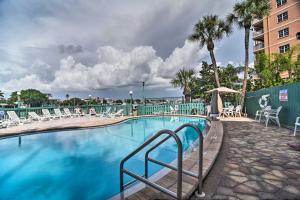 basen w hotelu z krzesłami i palmami w obiekcie Coastal Condo with Pool, Walk to Clearwater Beach! w mieście Clearwater Beach