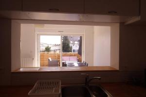 a kitchen with a sink and a view of a living room at Vannes centre logement 3 pièces avec terrasse in Vannes