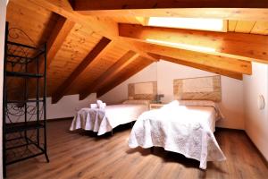 2 camas en una habitación con techos de madera en Casas Rurales Bestue-Ordesa, en Bestué
