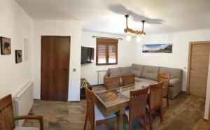 een woonkamer met een tafel en een bank bij Casas Rurales Bestue-Ordesa in Bestué