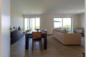 a dining room and living room with a table and a couch at Capa da Encosta in Amarante