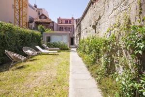 a group of chairs sitting next to a wall at Oporto Sweet Home I in Porto