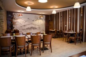 a restaurant with tables and chairs and a drawing on the wall at Penzión Na Kopečku in Súľov