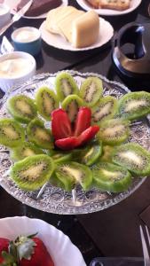 una placa de vidrio con kiwi y fresas sobre una mesa en Pousada Requinte Serrano, en Urubici