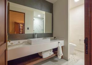 La salle de bains est pourvue d'un lavabo, d'un miroir et de toilettes. dans l'établissement Casa Barroca, à Puebla
