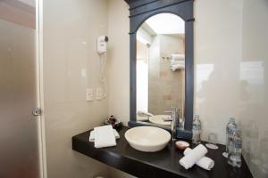 
a bathroom with a sink, mirror, and toilet at Hotel Rosario Lago Titicaca in Copacabana

