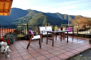 een patio met een tafel en stoelen en bergen bij Casa Rural Los Llares in Lerones