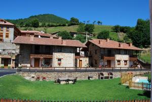 een groep gebouwen met een groen gazon aan de voorkant bij Casa Rural Los Llares in Lerones
