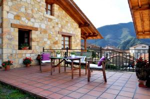 un patio avec une table et des chaises et un bâtiment dans l'établissement Casa Rural Los Llares, à Lerones