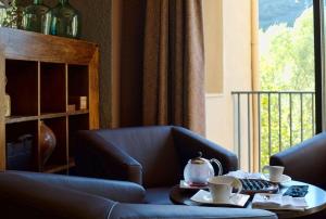 een woonkamer met een tafel met kopjes erop bij Hotel Cotori in El Pont de Suert