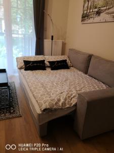 uma cama numa sala de estar com um sofá em Apartament Zuza em Polanica-Zdrój