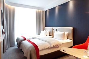 1 Schlafzimmer mit 2 Betten und einem großen Fenster in der Unterkunft Holiday Inn Express Frankfurt Airport - Raunheim, an IHG Hotel in Raunheim