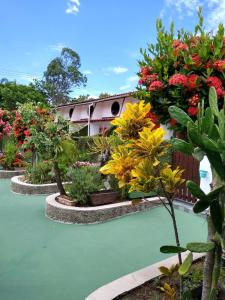 um jardim com flores e uma casa ao fundo em Condomínio Vila Gustavo -excelente localização em Caraguatatuba