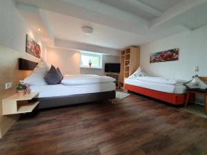 a large room with two beds and a desk at Stempfle's Landgasthaus zum Kreuz in Unterschneidheim