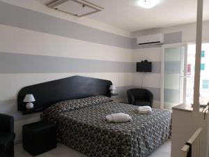 1 dormitorio con 1 cama con 2 toallas en Aa Ciasèa duu Pintùu, en Riomaggiore