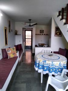 a living room with a table and a couch at Condomínio Vila Gustavo -excelente localização in Caraguatatuba