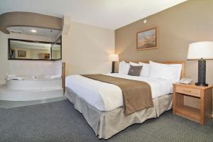Habitación de hotel con cama y bañera en Boarders Inn & Suites by Cobblestone Hotels - Faribault, en Faribault