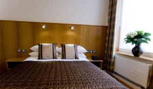 1 dormitorio con 1 cama grande y un jarrón de flores en Blooms Hotel en Dublín