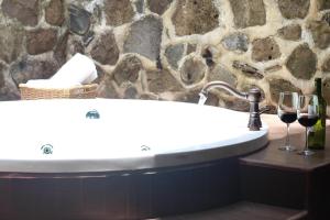 a bathroom with a bath tub with two glasses of wine at Bosque Escondido in Mazamitla