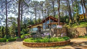 a house in the woods with flowers in front of it at Bosque Escondido in Mazamitla