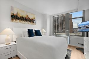 a white bedroom with a large white bed and a tv at Global Luxury Suites Crystal City in Arlington