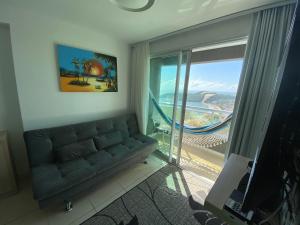 a living room with a couch and a sliding glass door at Blue Ocean Ponta Negra in Natal
