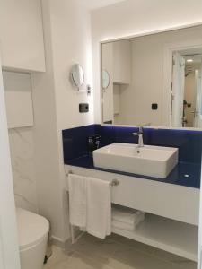 a bathroom with a sink and a toilet and a mirror at Orbi City in Batumi